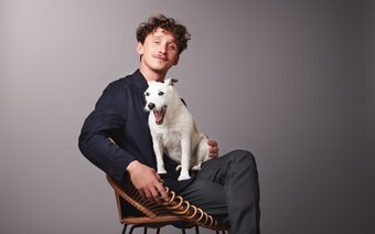 Junger Mann mit einem Hund am Schoß | © BASSENA Hotels
